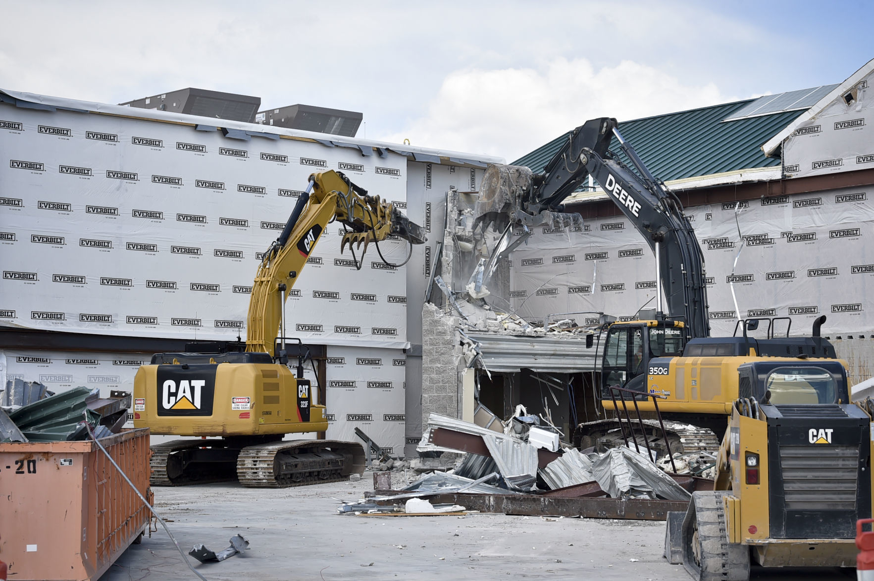 Excavators deconstruct a wall of the airport